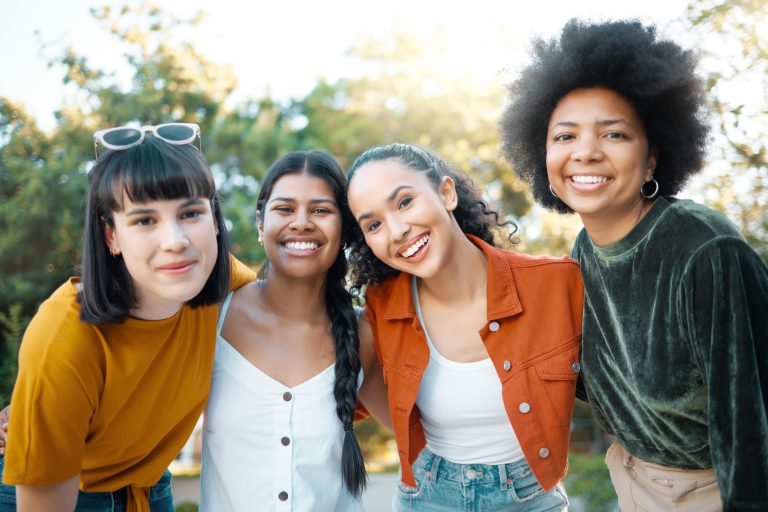 Four young women smiling outdoors