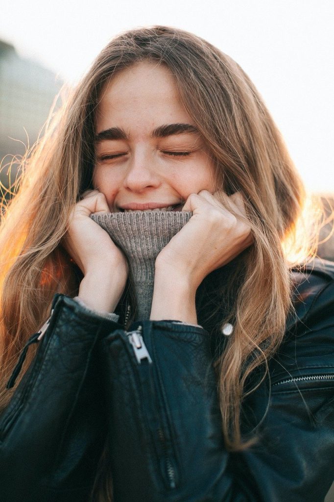 Young woman smiling in a cozy sweater